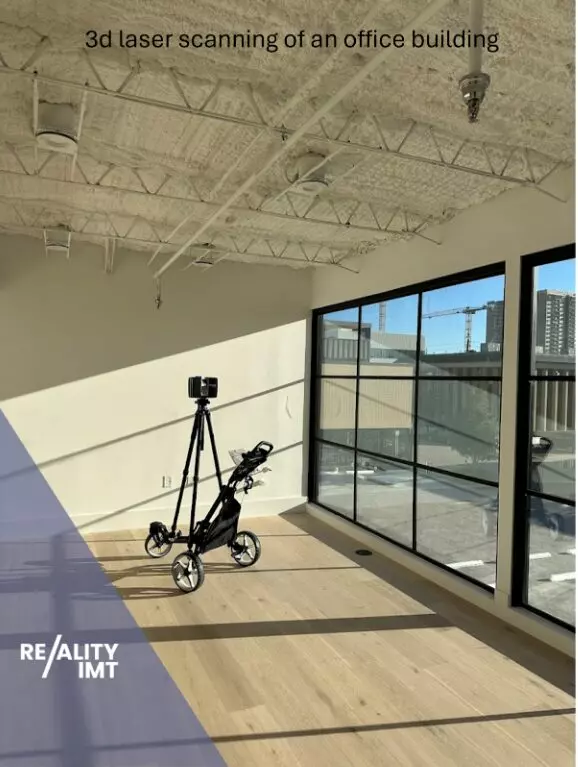 Reality IMT technician performing 3D laser scanning inside an office building to capture existing conditions for documentation and renovation planning.
